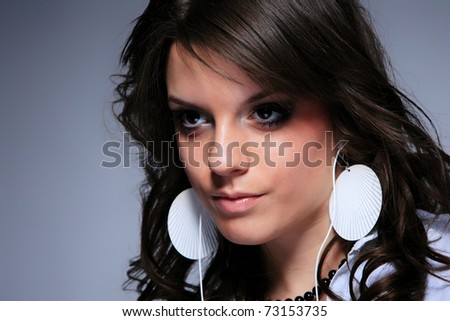 Beautiful Girl listening music with her cell phone over gray background