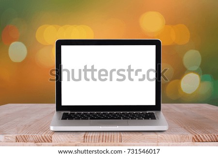 Front view of the laptop is on the work table with bokeh orange background 
