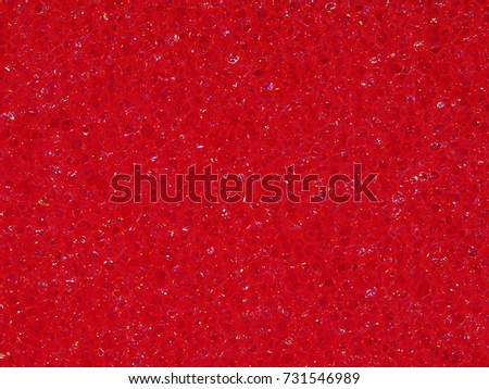Background macro texture of the banal red synthetic sponge for washing dishes