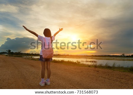 Free happy girl enjoying in nature, Little girl raise arm at sunset background.