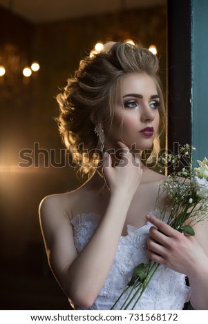 Blonde with long hair in a white dress and with a rose in your hands