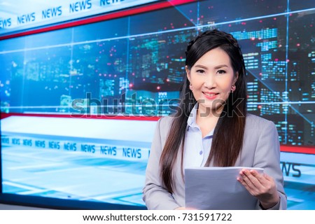 Beautiful Asian television newscaster at broadcast room