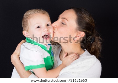 happy blonde child son kiss by pretty mother