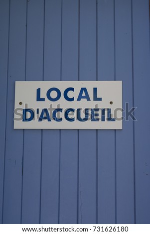 blue grey wood door for background with write in french local d'accueil means reception area