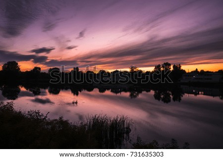 sunset in purple tones, landscape in the evening on the river bank