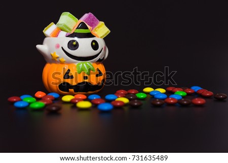 Halloween pumpkin doll head Jack lantern with candy on black background ,trick or treat