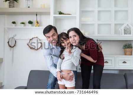 Happy family father, mother and daughter looking camera for take photography at home