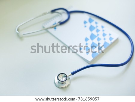 Medical phonendoscope of blue color and notebook for notes on a white background. Medical stethoscope for listening to lungs, for diagnosing diseases