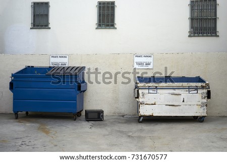 private parking signs above two commercial trash containers