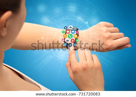 Hand with smartwatch and application symbols nearby.