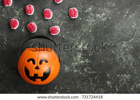 Terrible sweets (brains) for Halloween in decorative pumpkin on a dark background. Top view, copy space. Food background