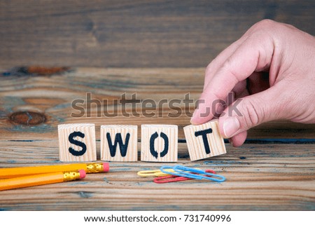 swot. Wooden letters on the office desk. Business and money investment background