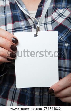 Vertical layout is a nominal mark in the hands on the background of a shirt in a cage. Person identity label. Business mockup design.