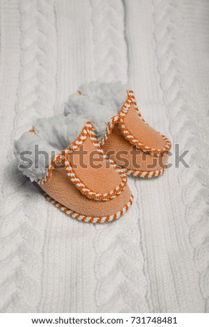orange warm baby shoes on a white isolated background