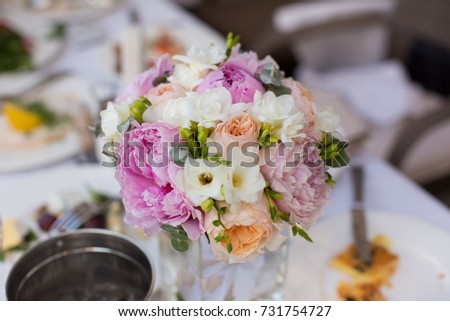 table decoration bouquet of flowers with peonies, eustoma and roses at the wedding