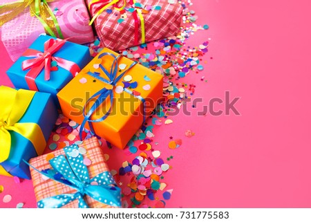 Colored gift boxes with colorful ribbons. Red background. Gifts for Christmas or birthday.