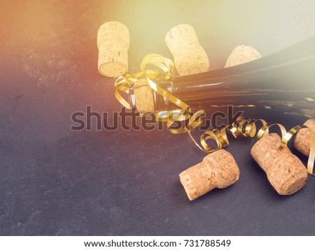 a bottle of champagne and a number of tubes, holiday concept, dark background