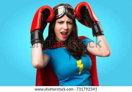 Frustrated pretty superhero girl  with boxing gloves on colorful background