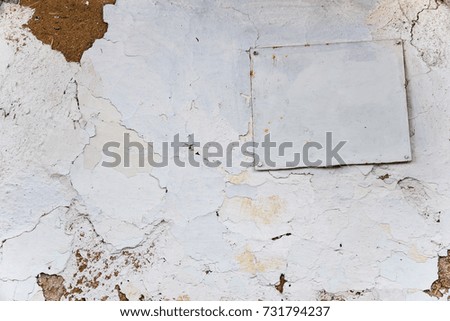 Wall whitewashed by lime in white color, nailed plate, textured background. Ukraine