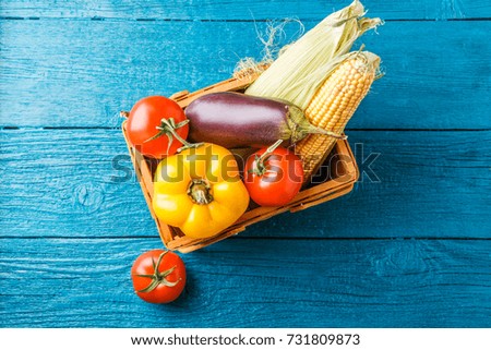 Image on top of basket with autumn vegetables on blue wooden table