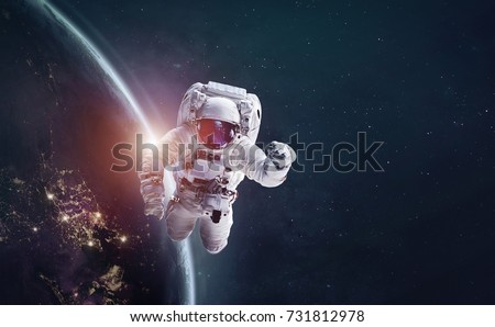 Astronaut in outer space over of the Earth with sun light. City lights on planet. Elements of this image furnished by NASA. Royalty-Free Stock Photo #731812978