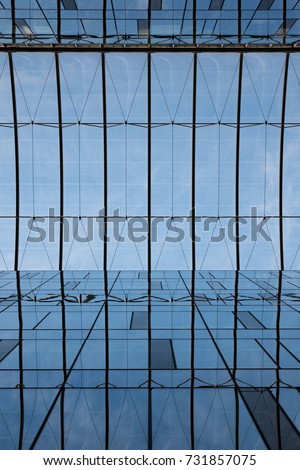 Glass office building reflections blue sky clouds business exterior corporate structure contemporary pattern smooth texture design architectural mosaic surface clean lines