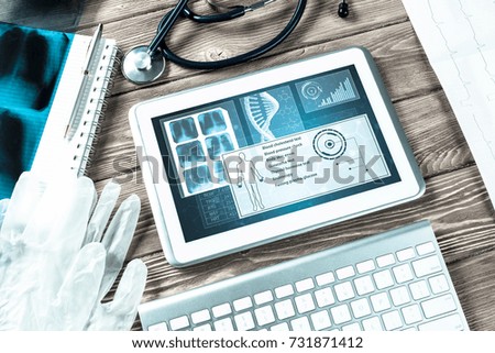 White tablet pc and doctor tools on wooden table