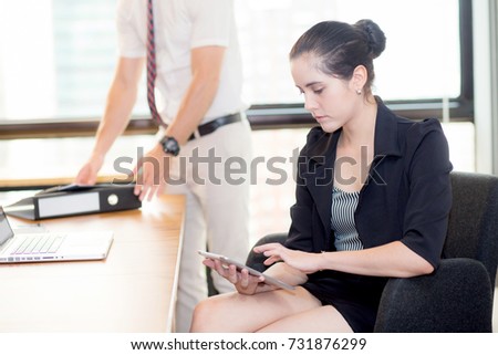 American portrait of businesswoman sitting in modern office business people background.