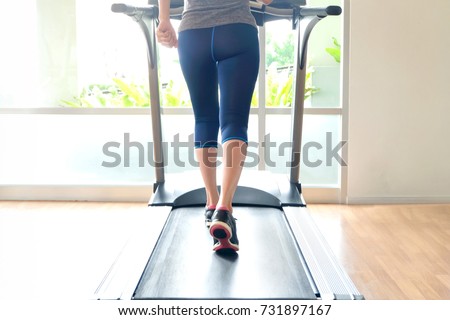 leg of woman running exercise  on treadmill in the gym which runner athletic by running shoes. Health and sport concept background,
