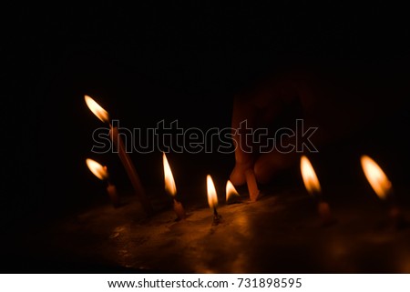 light candle burning brightly in the black background
