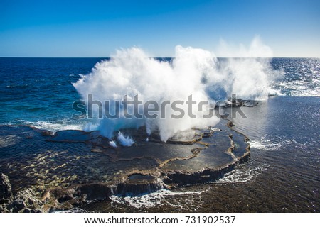 Powerful waves crashing into the reef, the famous Mapu'a 'a Vaea blowholes in Tonga Royalty-Free Stock Photo #731902537