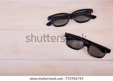 A pair of 3D glasses on the background of a wooden table