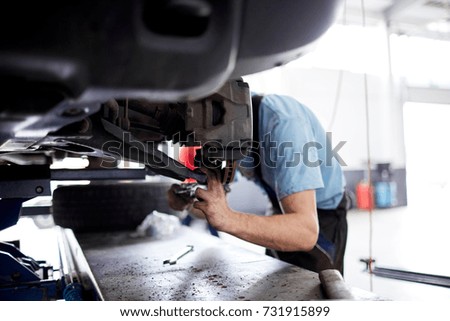 The mechanic repairs the brakes at the machine that broke
