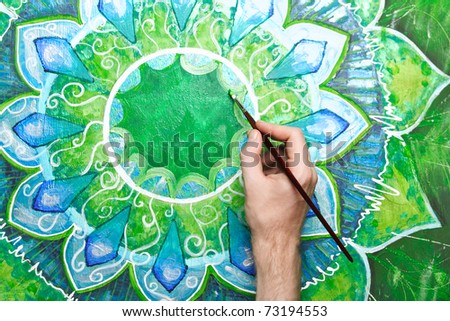 man painting bright green picture with circle pattern, mandala of anahata chakra