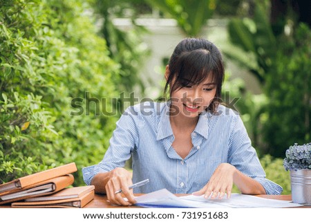 Young asian women writing homework on desk in outdoors, woman working with happy emotion concept. Vintage effect style pictures.