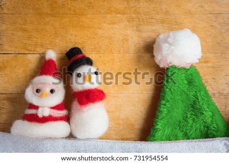 Top view or flat lay of cute santa claus and snowman doll decoration on wooden table with christmas tree, merry christmas, happy new year concept background