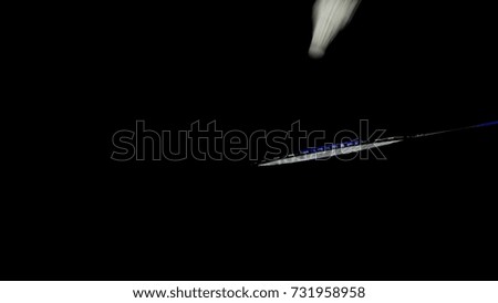 playing the badminton and shuttlecock is floating in the air on dark background