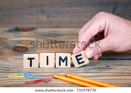 Time. Wooden letters on the office desk. Business and money investment background.
