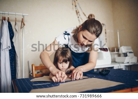 Mom and daughter sew clothes together. Pattern dress.