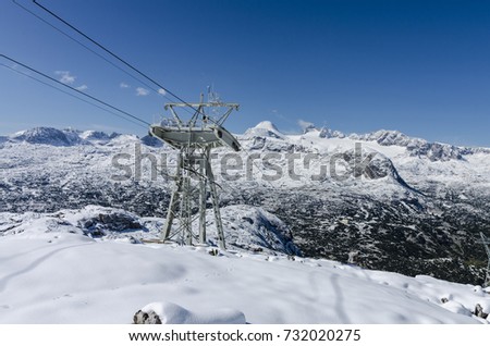 Snowy landscape - the view to the Dachstein top from the hiking track to Krippenstein with a cable car track and a trestle