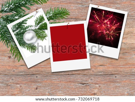 Three white picture frames on wooden background; Instant pictures with Christmas motif, Year's end motif and blank picture on weathered wooden wall, decorated with fir sprig; Christmas greeting card
