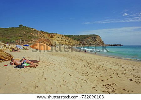 Holiday makers enjoying the early winter sun in Praia das Cabanas Velhas, near Burgau, Algarve, Portugal