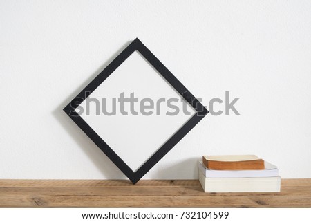 square frame with book on wooden table