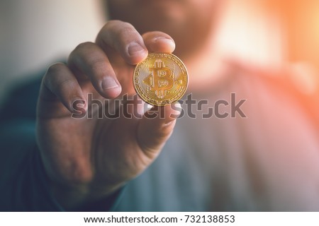 Cryptocurrency golden bitcoin coin. Man holding in hand symbol of crypto currency - electronic virtual money for web banking and international network payment, selective focus, toned Royalty-Free Stock Photo #732138853