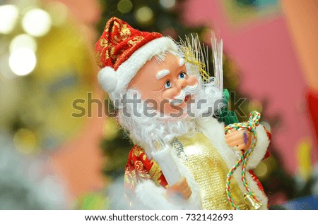 Santa claus doll in Christmas day on green grass and bokeh background. Morning sunshine day and good day.Happy time together in winter season