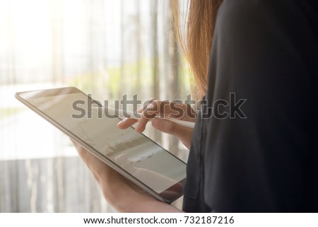 Business woman work with tablet. Stocker business graph up-down