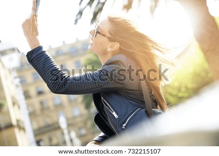 Trendy girl taking selfie picture in town