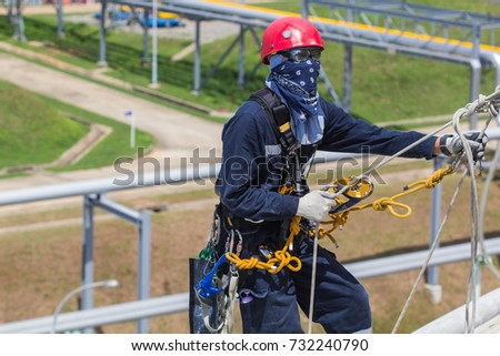 Focus  male worker rope access height handrail inspection of thickness storage propane  tank industry