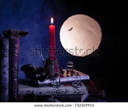 Halloween concept. old books, candle, scrolls, moon light