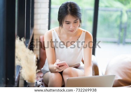 Young Asian start up Business woman using laptop computer.she works online shopping on laptops with hand on keyboard,holding digital tablet computer mobile smart phone,business concept,selective focus